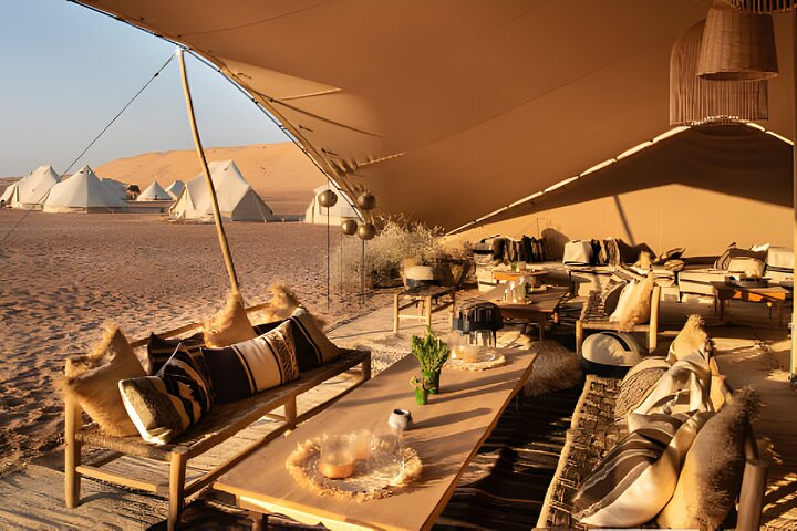 Experience the serenity of the desert with luxurious seating and stunning dune views perfect for savoring drinks and appetizers under the sun creating lasting memories in Dubai's enchanting landscape.
